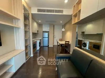 Modern living room with sleek kitchen and dining area, featuring built-in shelves and contemporary furniture.