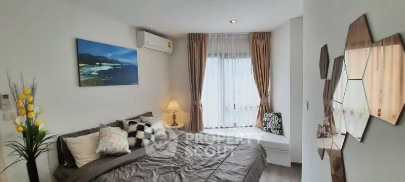 Cozy bedroom with modern decor and large window for natural light.