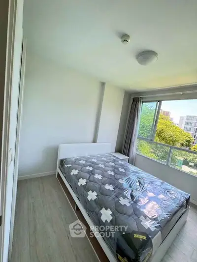 Bright bedroom with large window and modern decor in urban apartment