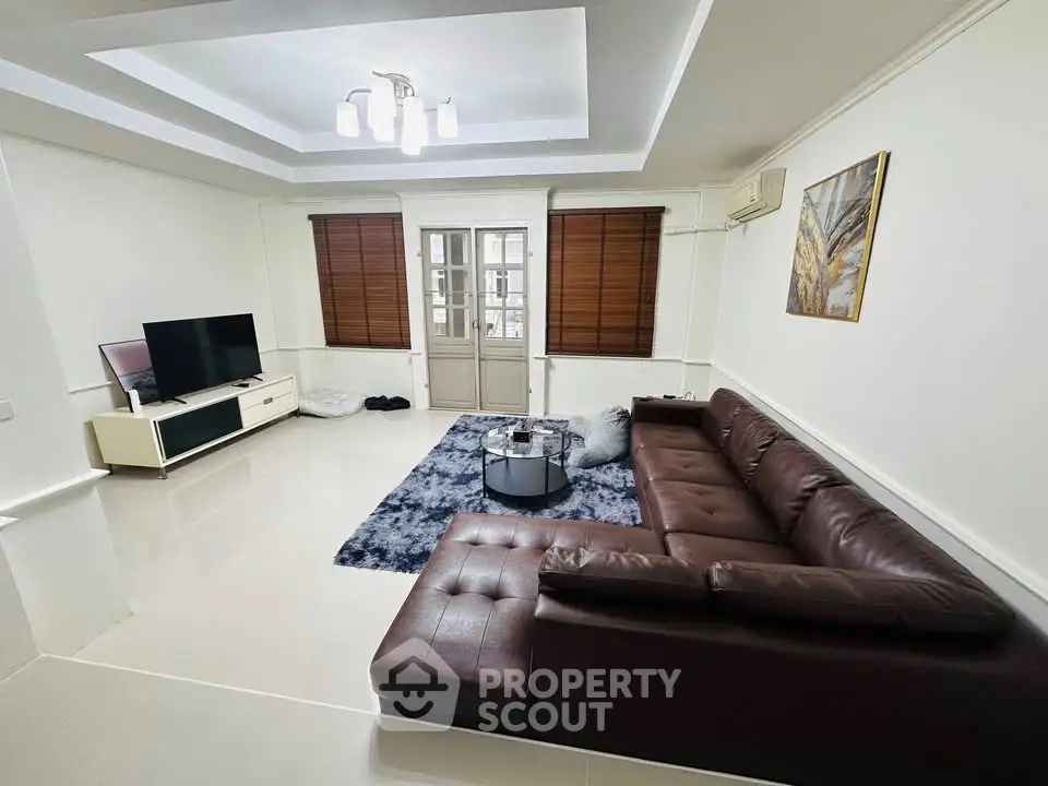 Spacious living room with modern decor and leather sectional sofa