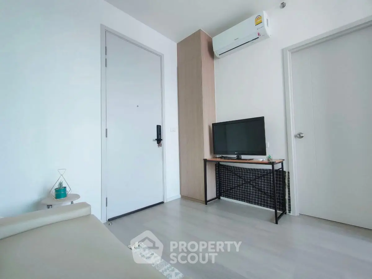 Modern minimalist living room with air conditioning and TV setup.
