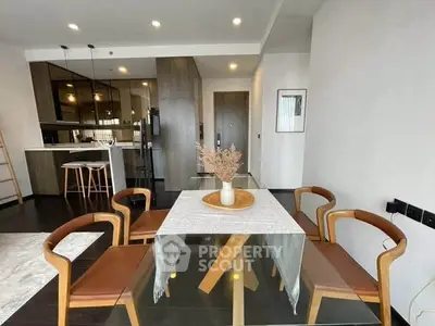 Modern dining area with glass table and stylish chairs in open-plan apartment