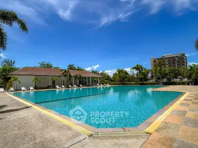 Luxurious outdoor pool area with clear blue water and palm trees, perfect for relaxation and leisure.