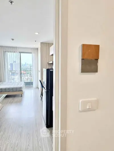 Modern apartment interior with city view, featuring a cozy bedroom and sleek design elements.