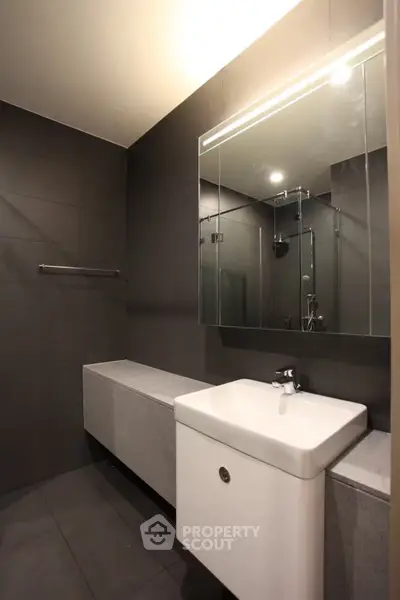 Modern bathroom with sleek design and large mirror in a contemporary apartment.