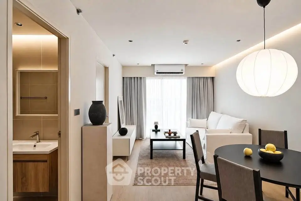 Modern living room with elegant decor and dining area, featuring a cozy ambiance and stylish lighting.