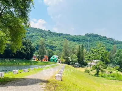 Scenic view of colorful houses by a lush green hillside and serene river.