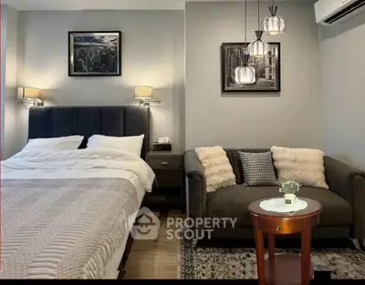 Cozy bedroom with stylish decor and comfortable seating area, perfect for relaxation.