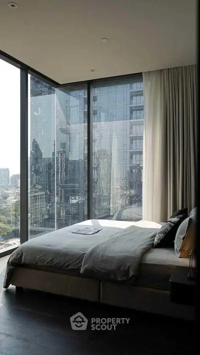 Luxurious bedroom with floor-to-ceiling windows offering stunning city views.