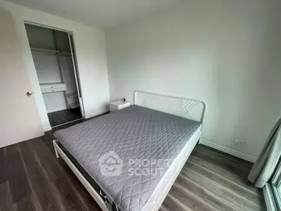 Spacious bedroom with modern design and ample natural light, featuring a large bed and built-in closet.