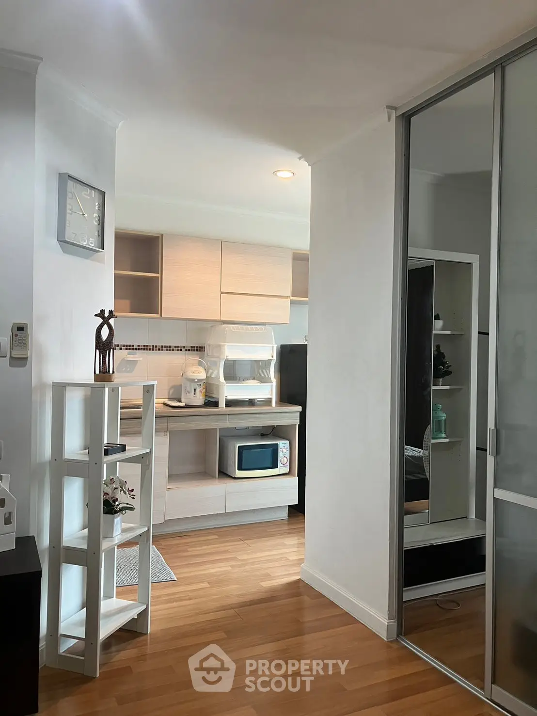 Modern kitchen with sleek cabinets and wooden flooring in a cozy apartment setting.