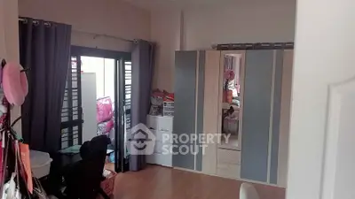 Spacious bedroom with modern wardrobe and balcony access, perfect for comfortable living.