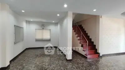 Spacious living room with elegant staircase and marble flooring