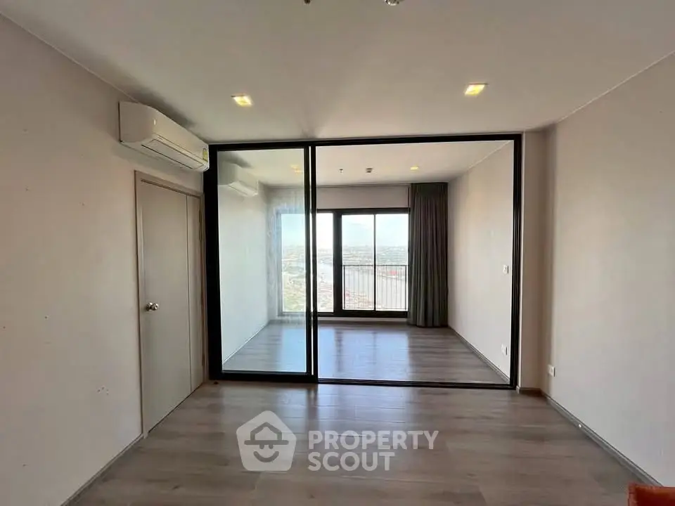 Spacious modern apartment with large windows and stunning city view, featuring sleek flooring and air conditioning.