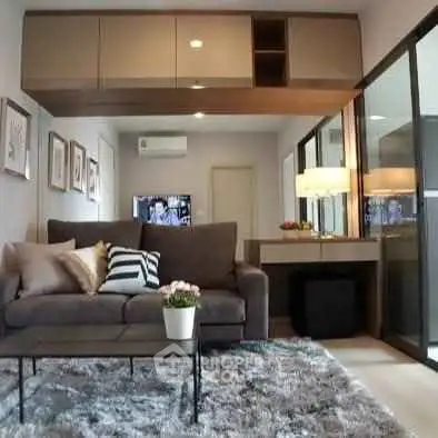 Modern living room with plush sofa, stylish decor, and large windows for natural light.