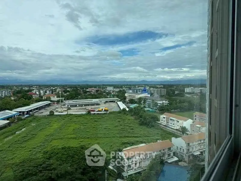 Stunning panoramic view from high-rise window overlooking lush greenery and urban landscape.
