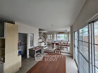 Spacious open-plan living area with dining table and large windows