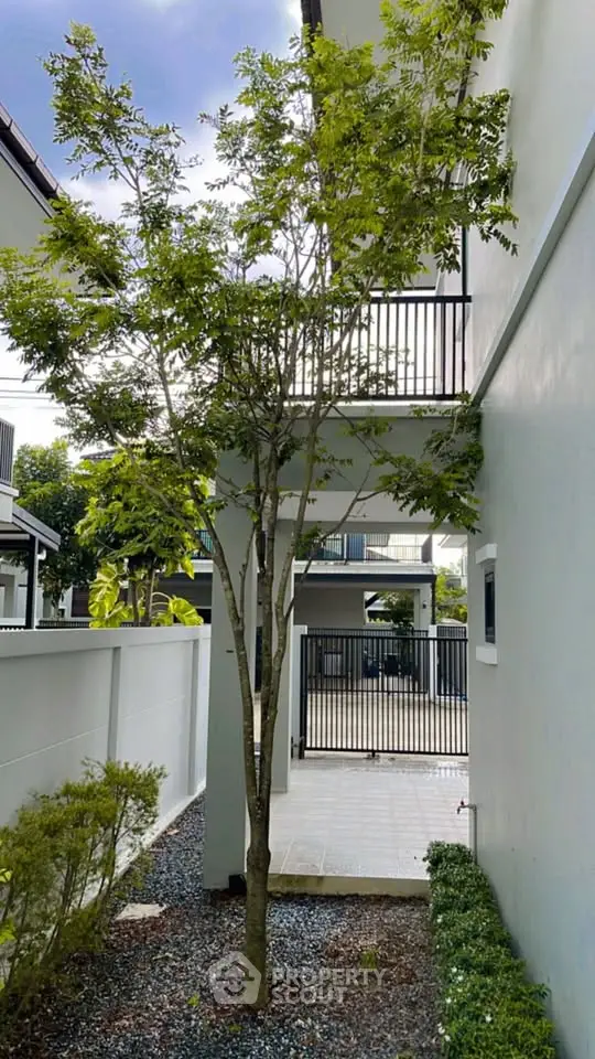 Modern house exterior with lush garden and balcony view