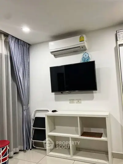 Modern living room with wall-mounted TV and air conditioning unit, sleek white shelving, and elegant curtains.