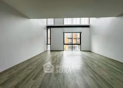 Spacious modern living room with high ceilings and large windows.