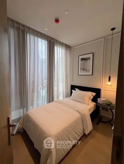 Cozy bedroom with elegant decor and natural light, perfect for relaxation.