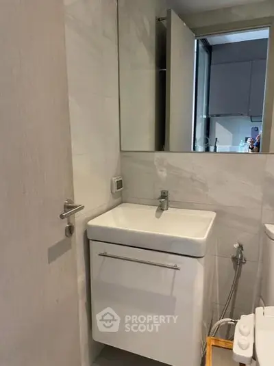 Modern bathroom with sleek sink and mirror in contemporary apartment.