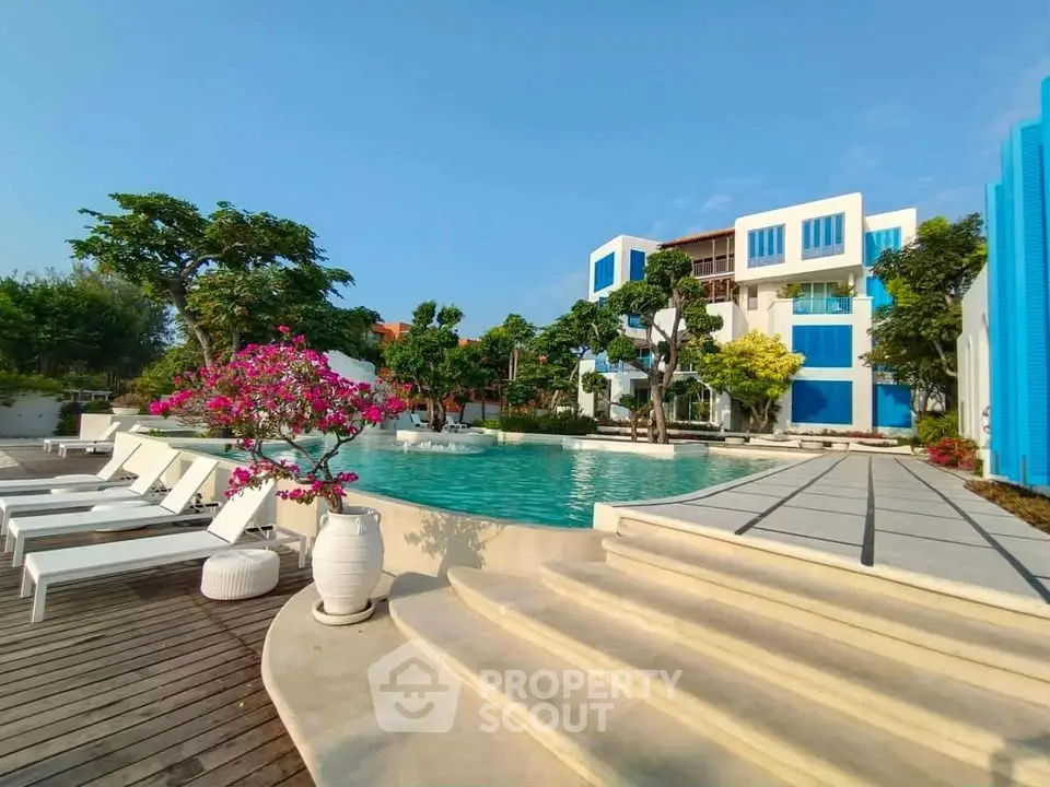 Luxurious poolside view of modern apartment complex with lush greenery and elegant design.