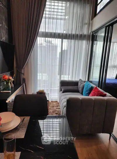 Modern living room with high ceilings and large windows in a stylish apartment.