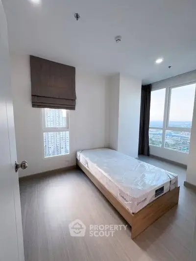 Modern minimalist bedroom with single bed and city view window