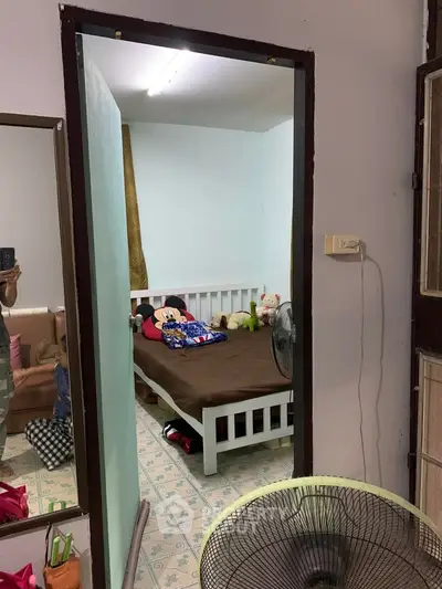 Cozy small bedroom with single bed and plush toys, ideal for a child's room.