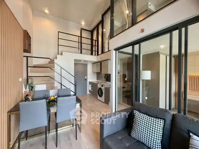 Modern duplex apartment with stylish interior, featuring open living area, dining space, and loft bedroom.
