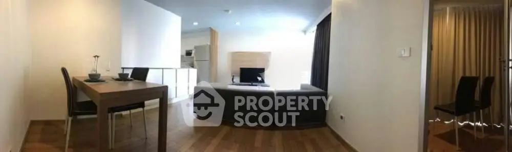Modern open-plan living room with dining area and sleek furniture in a stylish apartment.