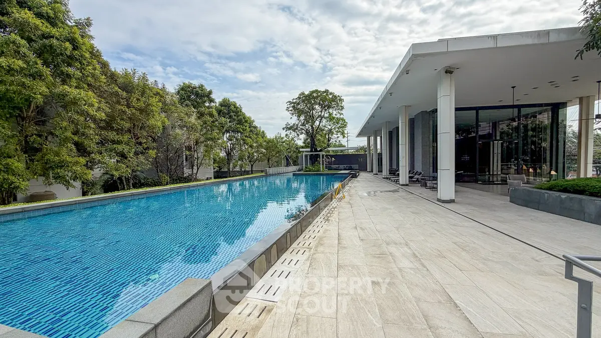 Luxurious poolside view with modern architecture and lush greenery, perfect for relaxation and leisure.