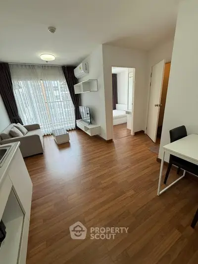 Modern apartment living room with wooden flooring and natural light