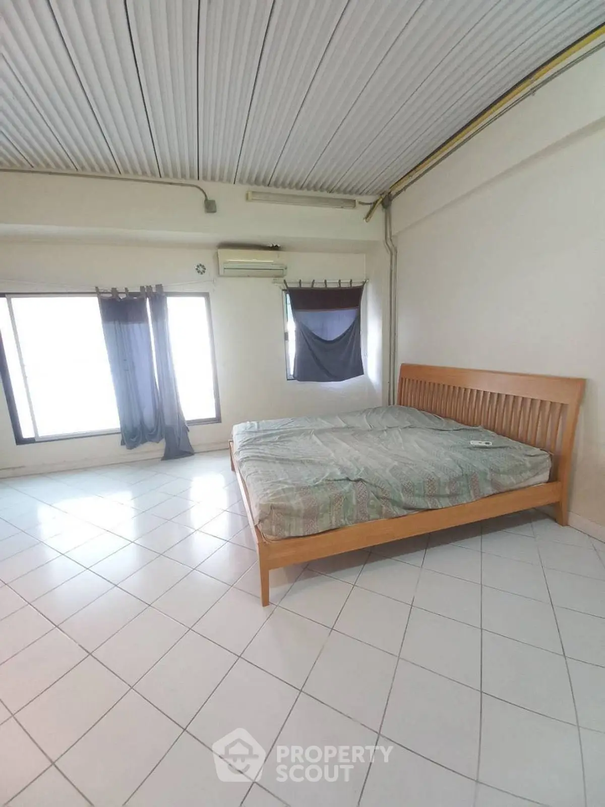 Spacious bedroom with large windows and minimalist decor