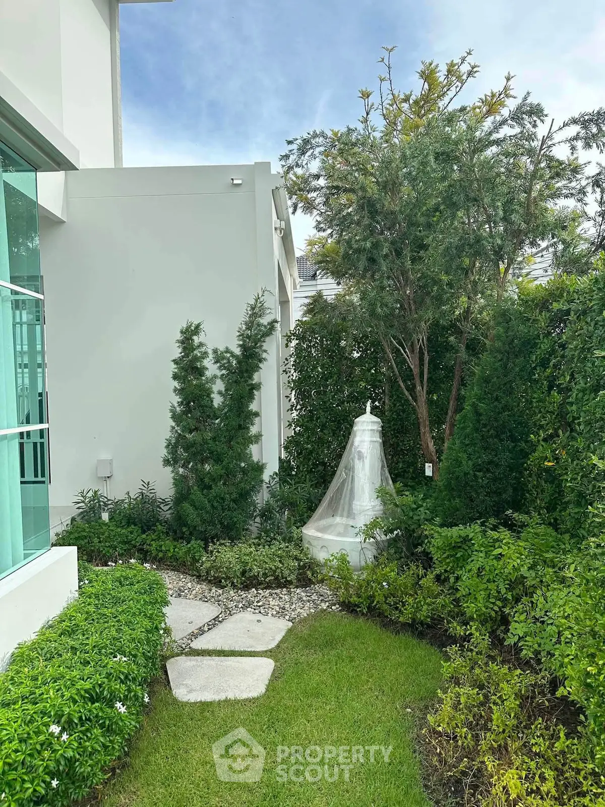 Charming garden view with lush greenery and modern architecture, perfect for tranquil outdoor living.