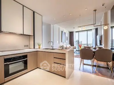 Modern open-layout kitchen and living room with stylish decor and ample natural light.