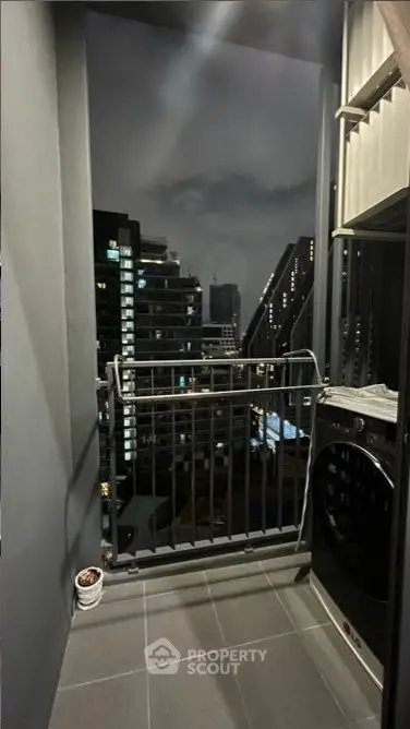 Modern balcony with city view and laundry area at night