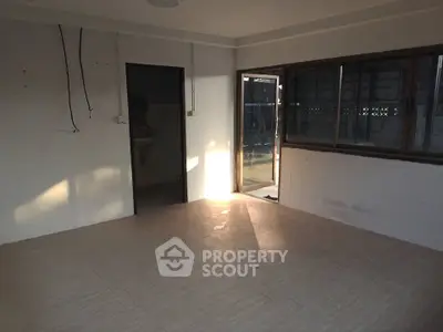 Spacious unfurnished room with large windows and natural light, ideal for customization.