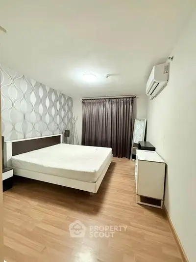 Spacious modern bedroom with stylish decor and wooden flooring