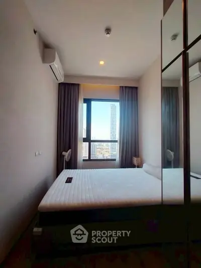 Modern bedroom with city view, featuring a comfortable bed and sleek design.