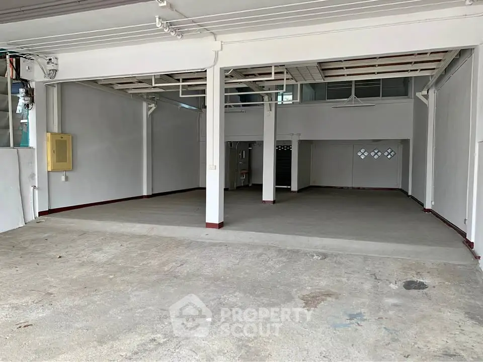 Spacious open garage or warehouse space with high ceilings and ample room for storage or parking.