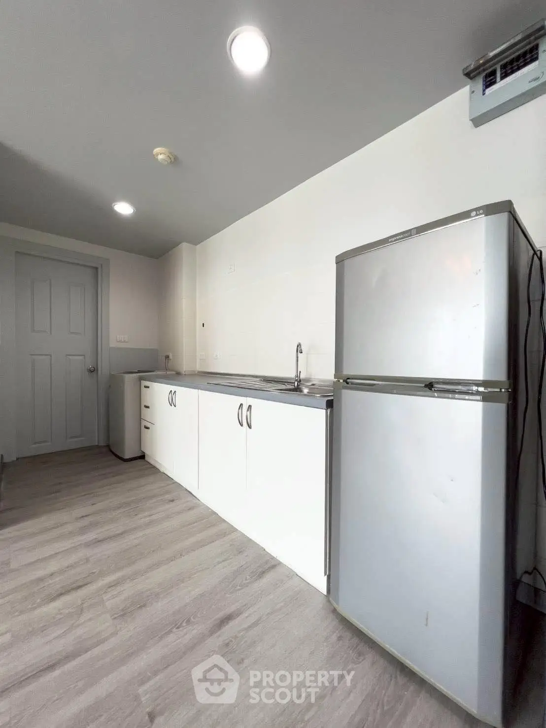 Modern kitchen with sleek cabinets and stainless steel fridge in a minimalist design.