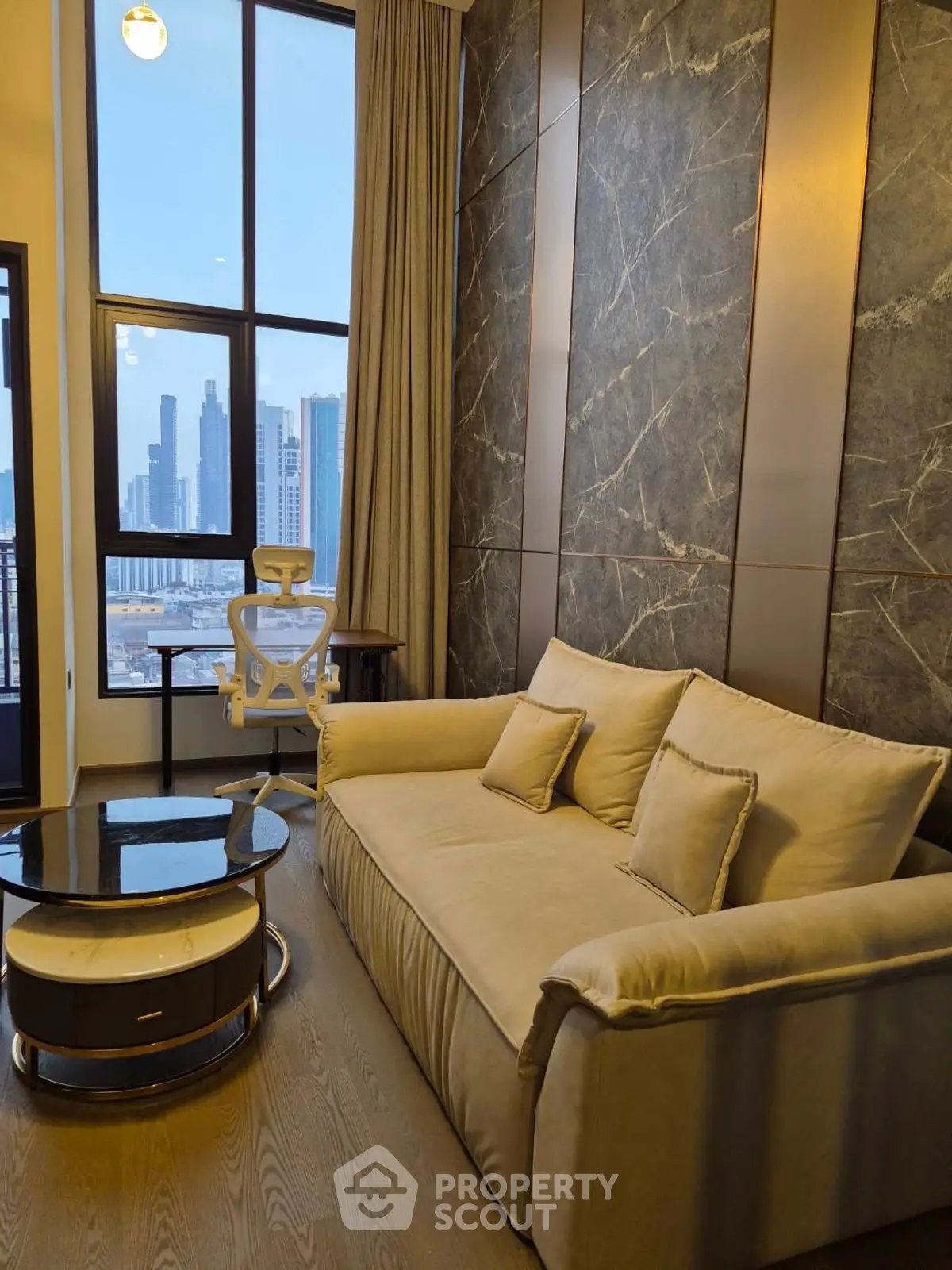 Luxurious living room with modern sofa and stunning city view through large windows.