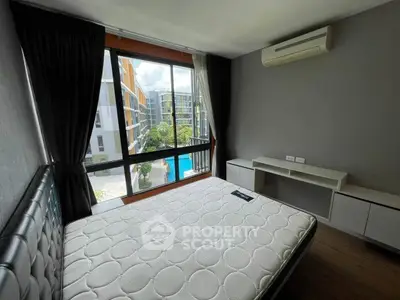 Modern bedroom with large window overlooking pool and air conditioning unit.