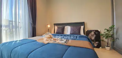 Cozy bedroom with stylish decor and natural light, featuring a comfortable bed and modern accents.