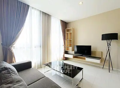 Modern living room with sleek furniture and large windows for natural light.