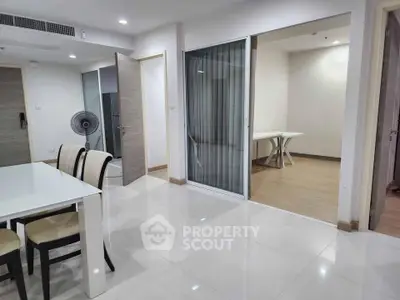 Spacious modern apartment with open layout dining area and study room, featuring sleek white interiors and elegant furnishings.