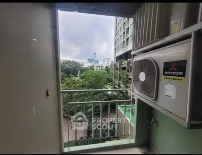 Charming balcony view with lush greenery and cityscape, featuring a heavy-duty air conditioning unit.