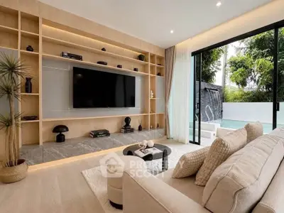Luxurious living room with modern decor and pool view, featuring a large TV and elegant shelving.
